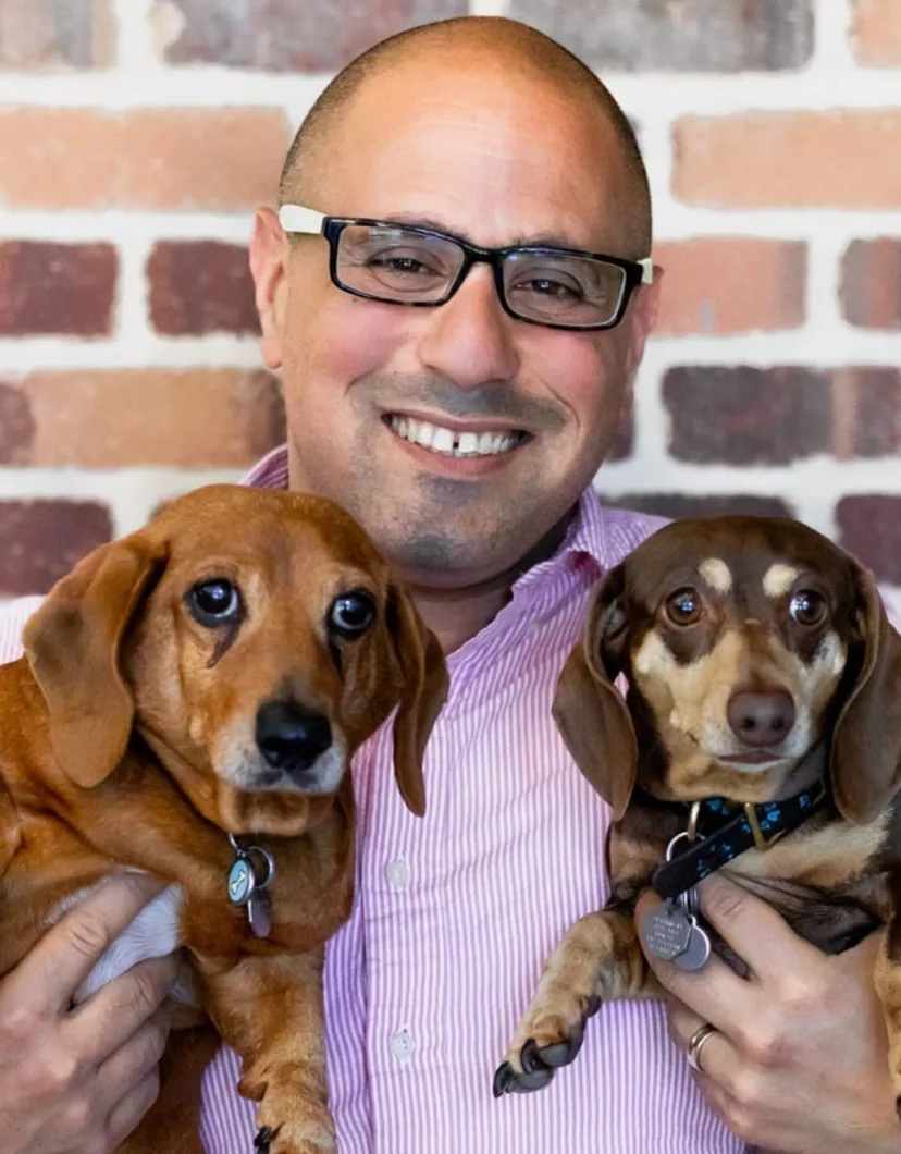 Dr. Moshe Oz, Vet at Rose Valley Veterinary Hospital, holding two dogs